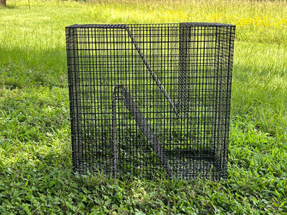A black metal fish trap on a grass yard.,